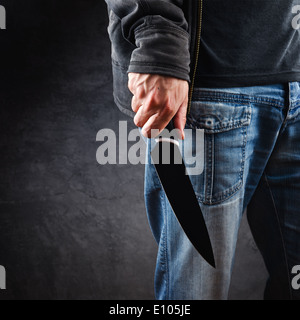 Evil man with shiny knife - a killer person with sharp knife about to commit a homicide, murder scenery. Stock Photo