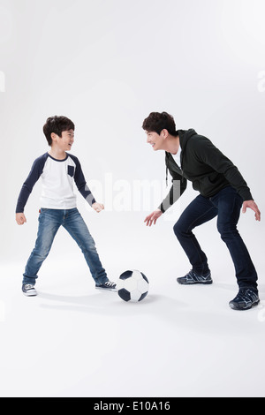 Father and son playing football Stock Photo - Alamy
