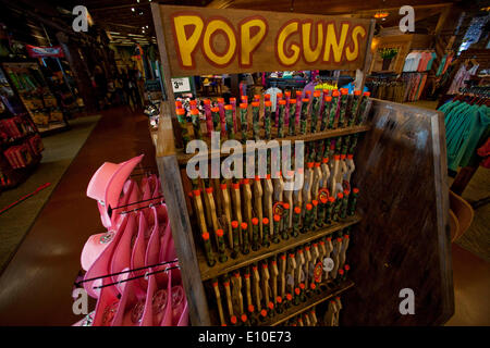 May 18, 2014 - Riverside, California, U.S. - Wooden toy pop guns for kids  on sale beside pink cowgirl stetson hats in a large Bass Pro Shops store in  Riverside. Bass Pro
