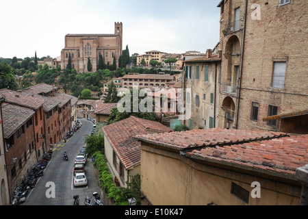 Via di Fontebranda street and surrounding old buildings in Siena, Italy with Gothic Basilica of San Domenico in the background. Stock Photo