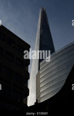 London, UK. 21st May 2014. 21 May 2014, London UK. A commuter is silhouetted against the Shard Skyscraper as London wakes to a beautiful summers morning. Credit:  Patricia Phillips/Alamy Live News Stock Photo