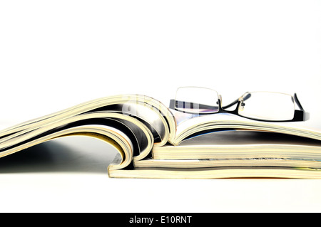 Open magazines with black glasses on white background Stock Photo