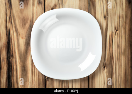 Empty white plate on wooden table background. Top view Stock Photo