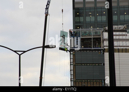 Steeplejacks installing glass window panels at the office building of 6 Bevis Marks in The City of London Stock Photo