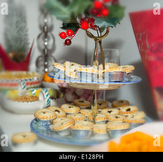 Mince pie christmas cakes with holly and bauble decorations over red ...