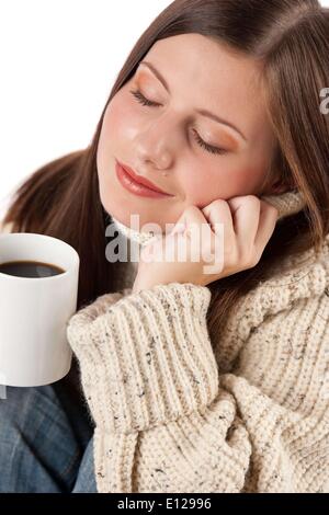 Oct. 29, 2009 - Oct. 29, 2009 - Winter portrait of happy woman holding cup of coffee wearing turtleneck on white Stock Photo