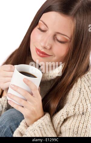 Oct. 29, 2009 - Oct. 29, 2009 - Winter portrait of happy woman holding cup of coffee wearing turtleneck on white Stock Photo