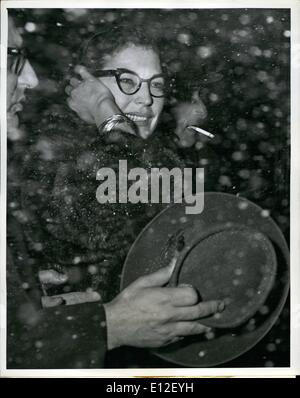 Dec. 21, 2011 - N.Y. International Airport, March 23, 1960. Glamorous screen star Ava Gardner flanked by two unidentified traveling companions emerges amidst the snow flakes late last night following her TWA supejet arrival from London. Stock Photo