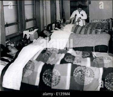 Feb. 29, 2012 - ''DOCTOR COURAGEOUS'' ATTENDING HIS PATIENTS: Standing on his crutches, Dr. Watanabe takes the pulse of one of his patients. Note: in Japan,hospital patients provide their own bedding. Stock Photo