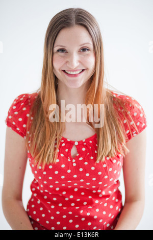 Studio portrait of happy smiling attractive woman wearing red blouse Stock Photo