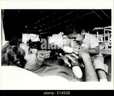 Apr. 04, 2012 - A Cuban refugee plays with his son as they lay on the cot assigned to them at the tent city in the Fort Walton Beach fairgrounds. Stock Photo
