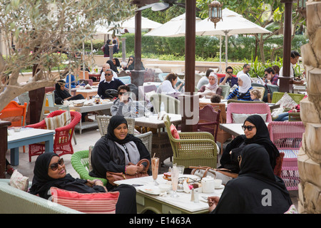 United Arab Emirates, Dubai, Local women chatting on outdoor terrace near Souk Al Bahar Stock Photo