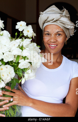 Mixed race woman holding bouquet of flowers Stock Photo