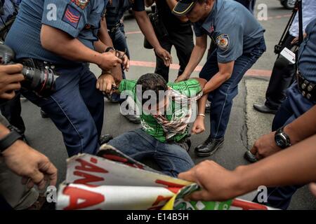 Makati, Philippines. 22nd May, 2014. Police officers arrest a demonstrator during a protest near the venue of the World Economic Forum on East Asia at the financial district of Makati, south of Manila, Philippines, May 22, 2014. Demonstrators criticized the Philippine government for allegedly hiding the worsening poverty and rampant corruption in the country as it welcomes foreign leaders and business heads during Asia's version of the World Economic Forum.Photo: Ezra Acayan/NurPhoto Credit:  Ezra Acayan/NurPhoto/ZUMAPRESS.com/Alamy Live News Stock Photo