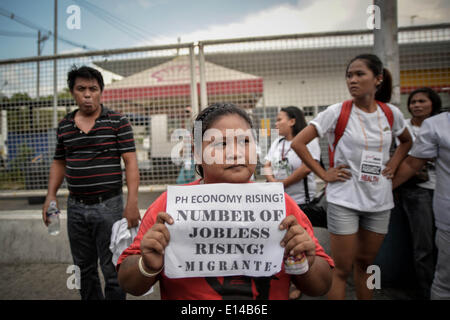 Makati, Philippines. 22nd May, 2014. A demonstrator holds up a placard during a protest near the venue of the World Economic Forum on East Asia at the financial district of Makati, south of Manila, Philippines, May 22, 2014. Demonstrators criticized the Philippine government for allegedly hiding the worsening poverty and rampant corruption in the country as it welcomes foreign leaders and business heads during Asia's version of the World Economic Forum.Photo: Ezra Acayan/NurPhoto Credit:  Ezra Acayan/NurPhoto/ZUMAPRESS.com/Alamy Live News Stock Photo