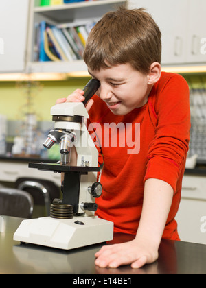 Caucasian boy using microscope in chemistry lab Stock Photo
