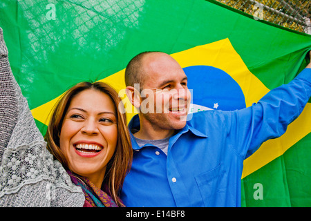 Hispanic couple holding Brazilian flag Stock Photo
