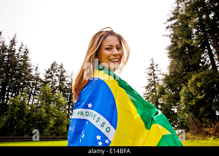 Hispanic woman wrapped in Brazilian flag Stock Photo