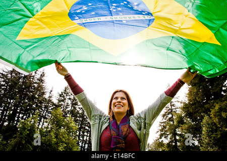 Hispanic woman flying Brazilian flag Stock Photo