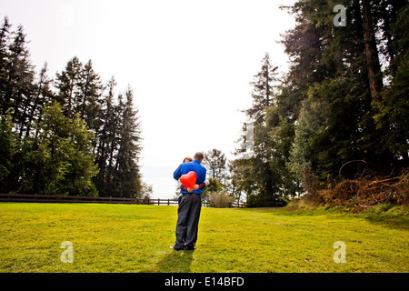 Hispanic couple hugging in park Stock Photo