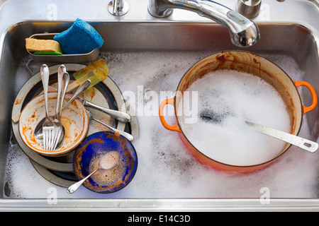 Kitchen sink full of dirty dishes Stock Photo