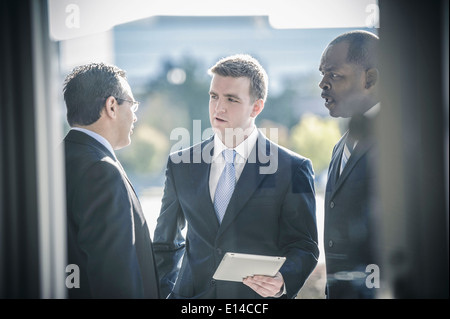 Businessmen using digital tablet outside office Stock Photo