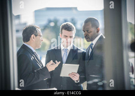 Businessmen using digital tablet outside office Stock Photo