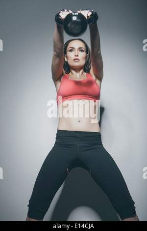 Caucasian woman lifting kettle bell Stock Photo