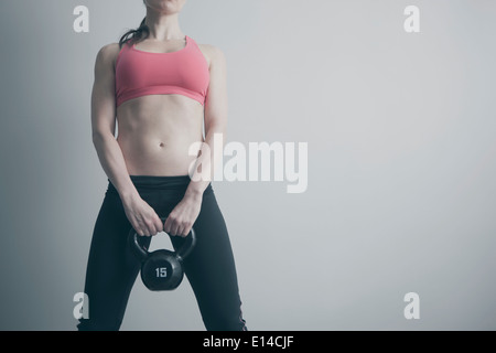 Caucasian woman holding kettle bell Stock Photo