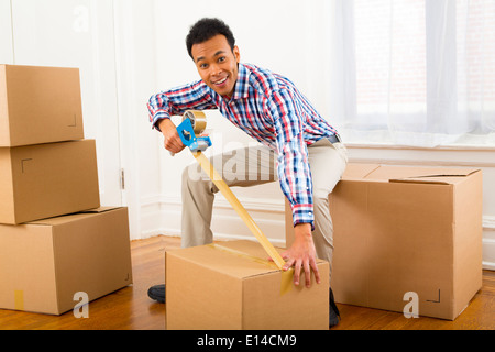 Mixed race man packing cardboard boxes Stock Photo