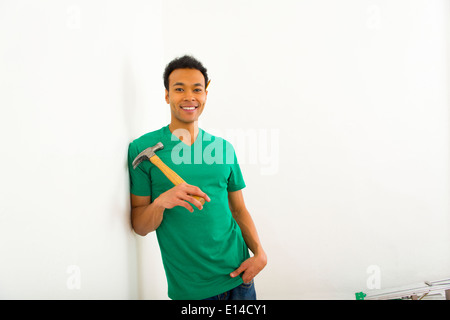 Mixed race man holding hammer Stock Photo