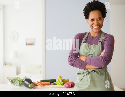 Portrait of black woman cooking in kitchen Stock Photo