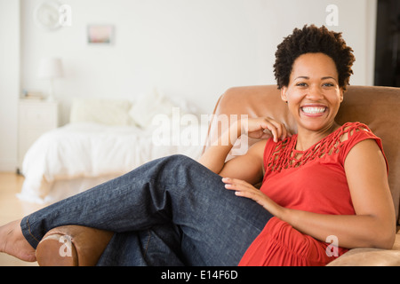 Portrait of smiling Black woman in armchair Stock Photo