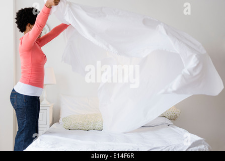 Black woman making bed Stock Photo
