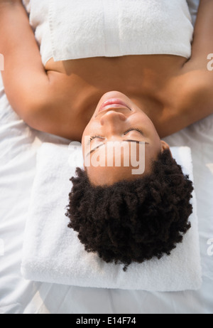 Serene Black woman laying on massage table Stock Photo