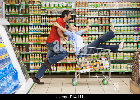 Caucasian couple playing in grocery store Stock Photo