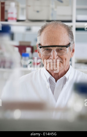 Senior Caucasian scientist smiling in lab Stock Photo