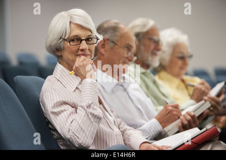 Senior Caucasian students taking notes in classroom Stock Photo
