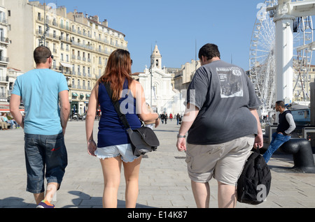 Three Young Adults including Large Obese Fat Man Walking on Quai du Port Old Port Marseille France Stock Photo