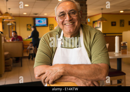 Hispanic server smiling in cafe Stock Photo