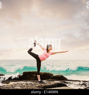 Caucasian woman stretching on beach Stock Photo