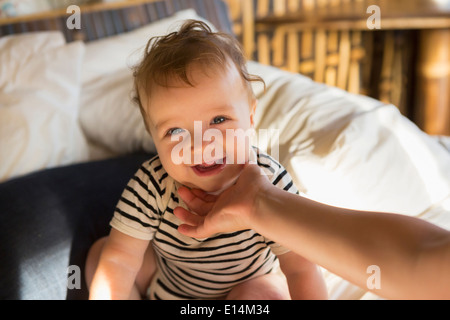 Caucasian baby laughing on bed Stock Photo