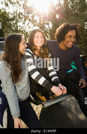 Friends sitting together in truck bed Stock Photo