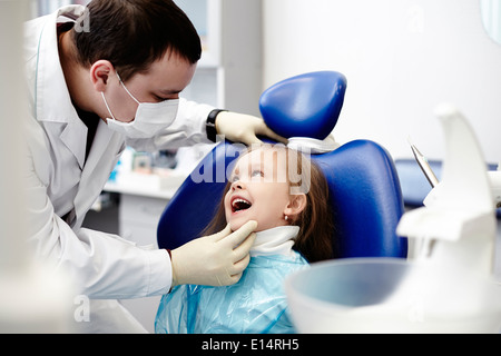 Caucasian dentist examining girl's teeth Stock Photo
