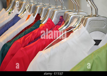 Colorful clothes hanging in wardrobe Stock Photo
