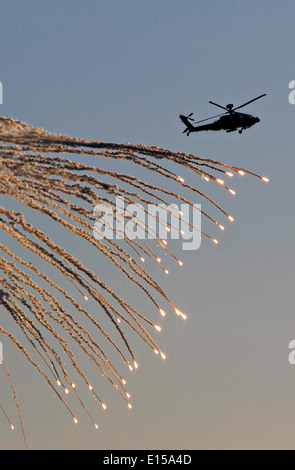 A British Royal Army AH-64 Apache helicopter destroys a target using CRV7 rockets and gunfire at the Barry M. Goldwater Range Crimson Eagle training exercise May 3, 2014 in Gila Bend, Arizona. Stock Photo