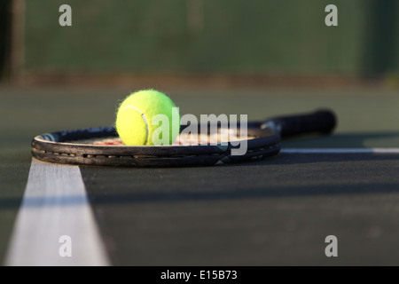 Tennis racket, ball laying on court. Stock Photo