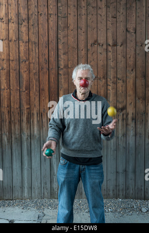 Senior man juggling with three balls Stock Photo