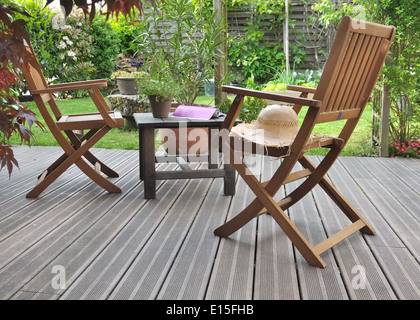 chairs and table on wooden terrace in garden Stock Photo
