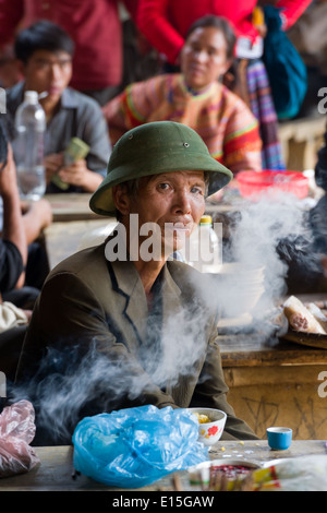 Vietnamese man at Can Cau market smoking from a bamboo water bong Stock ...